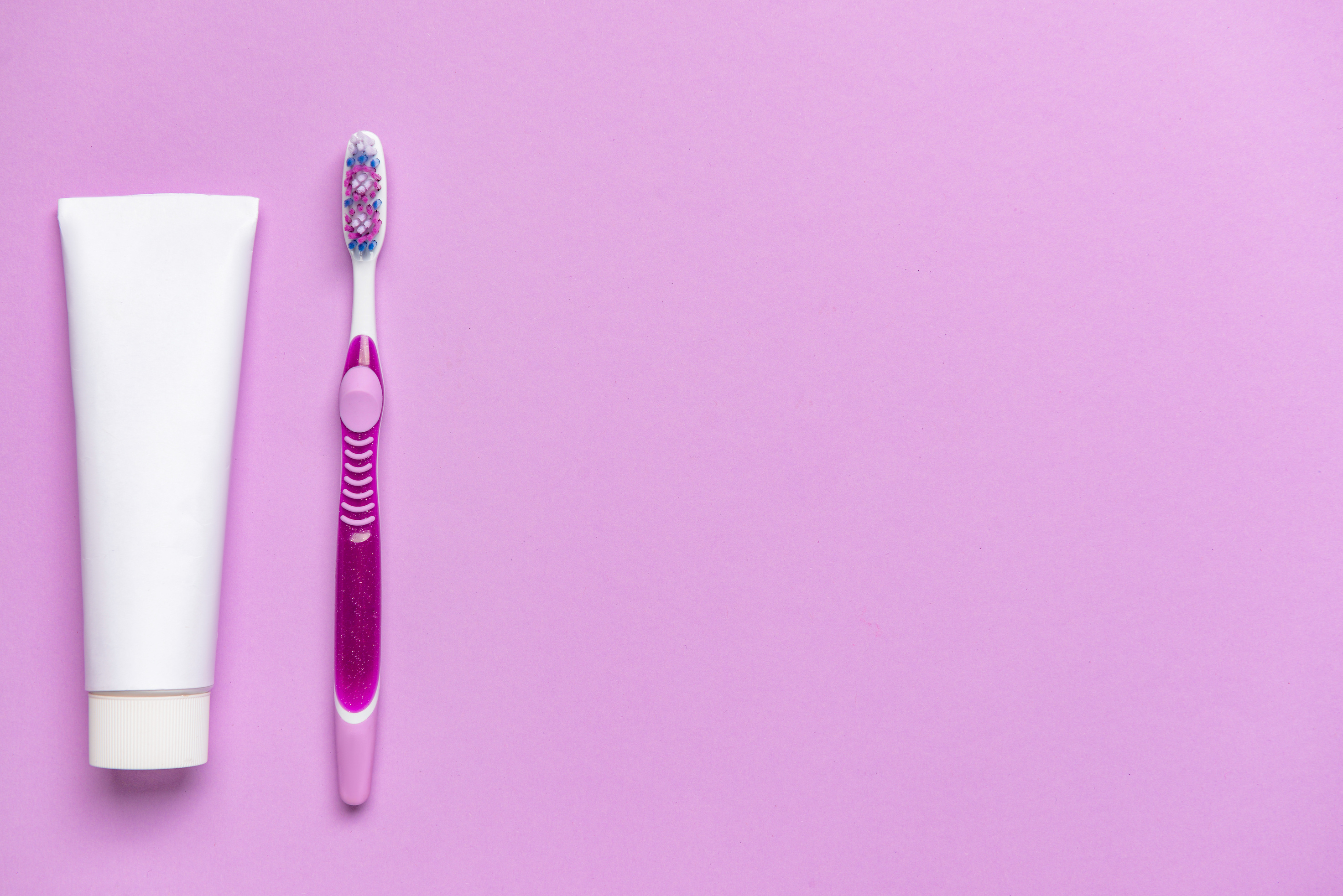Toothbrush and Paste on Purple Background